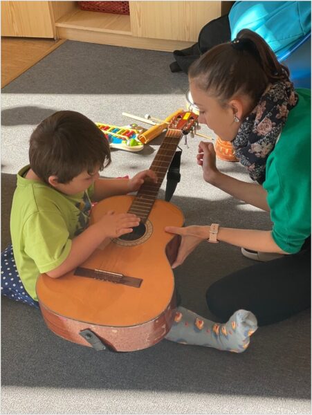 Mateřská škola - hudební výchova - dítě brnká na kytaru